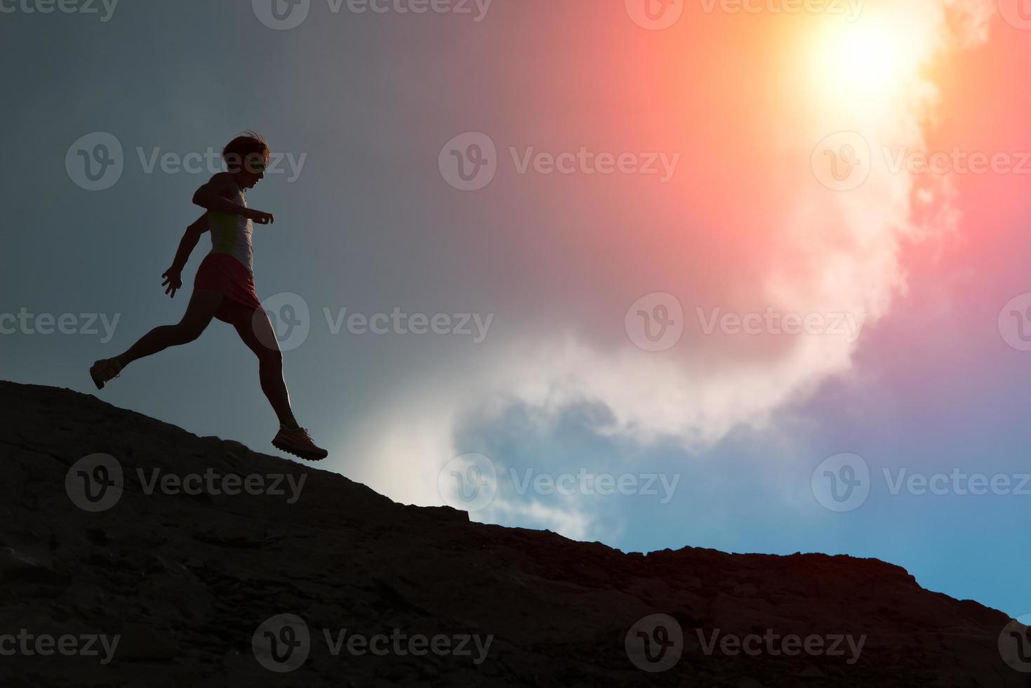 la donna corre sul crinale con il sole colorato foto