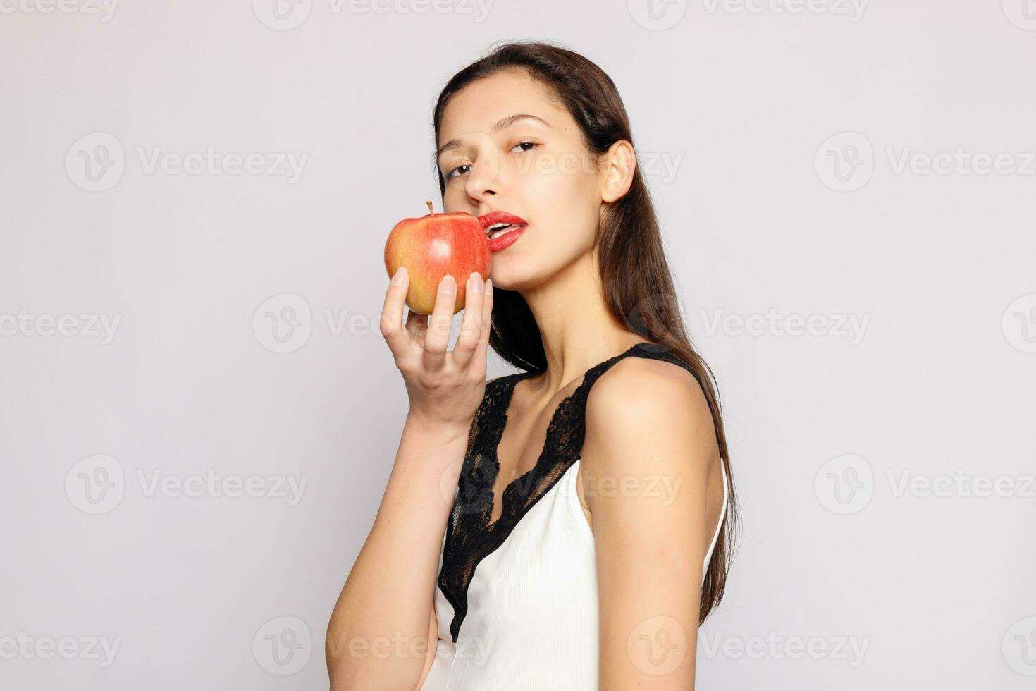 salutare mangiare. donna pungente rosso Mela con Perfetto denti foto