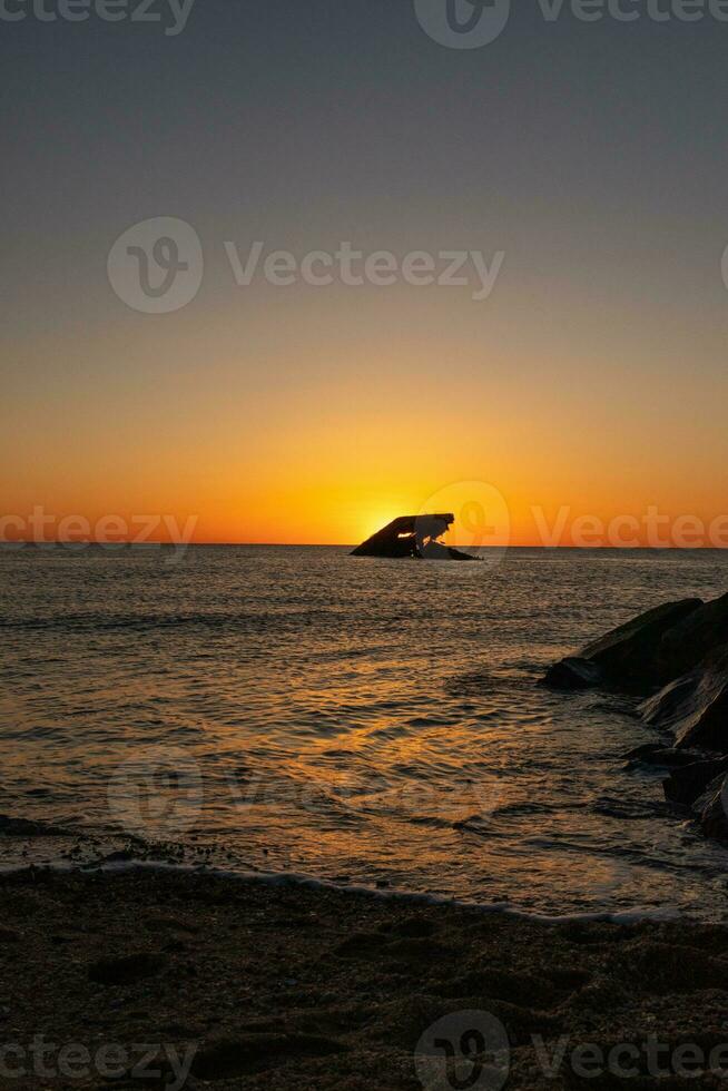 tramonto spiaggia nel capo Maggio nuovo maglia dove voi può ottenere un' grande Visualizza di il sole andando giù attraverso il oceano e il baia. il riflessione di il sole su il acqua con il affondata nave sembra così Bellissima. foto