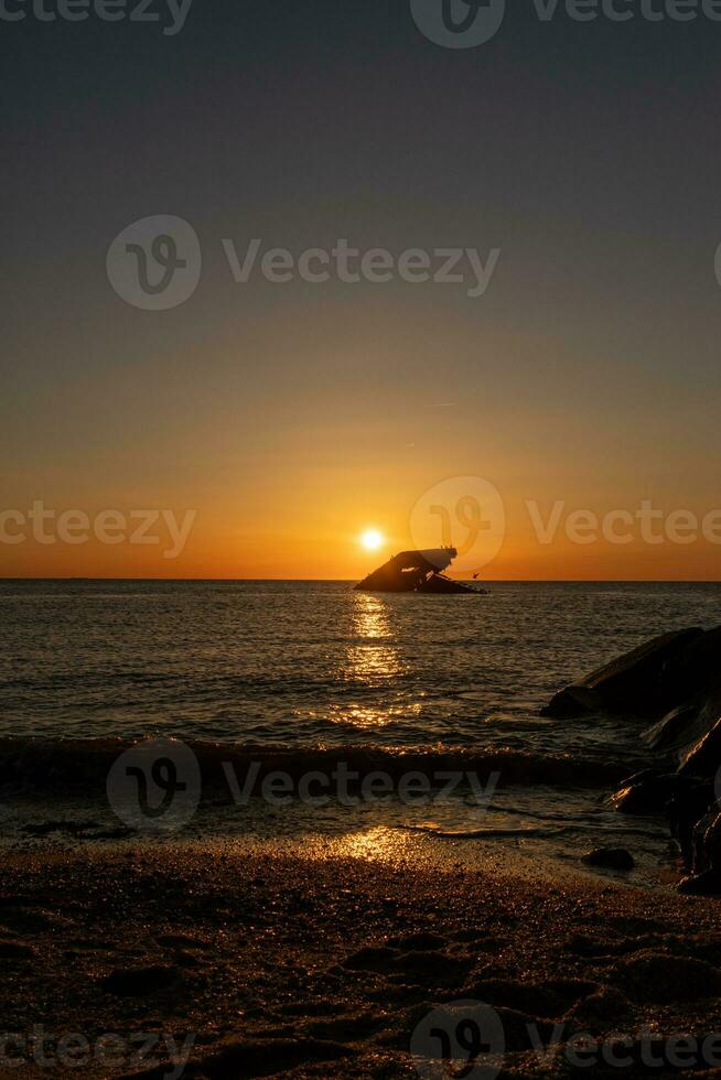 tramonto spiaggia nel capo Maggio nuovo maglia dove voi può ottenere un' grande Visualizza di il sole andando giù attraverso il oceano e il baia. il riflessione di il sole su il acqua con il affondata nave sembra così Bellissima. foto