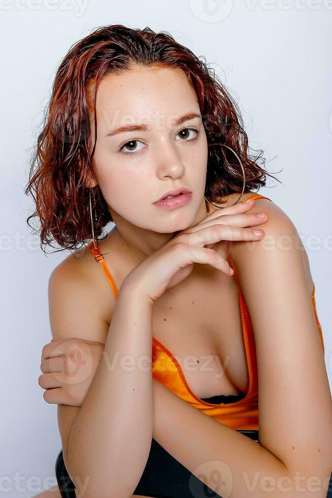 ritratto di attraente ragazza nel arancia vestito nel il studio foto