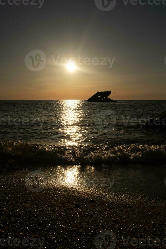 tramonto spiaggia nel capo Maggio nuovo maglia dove voi può ottenere un' grande Visualizza di il sole andando giù attraverso il oceano e il baia. il riflessione di il sole su il acqua con il affondata nave sembra così Bellissima. foto