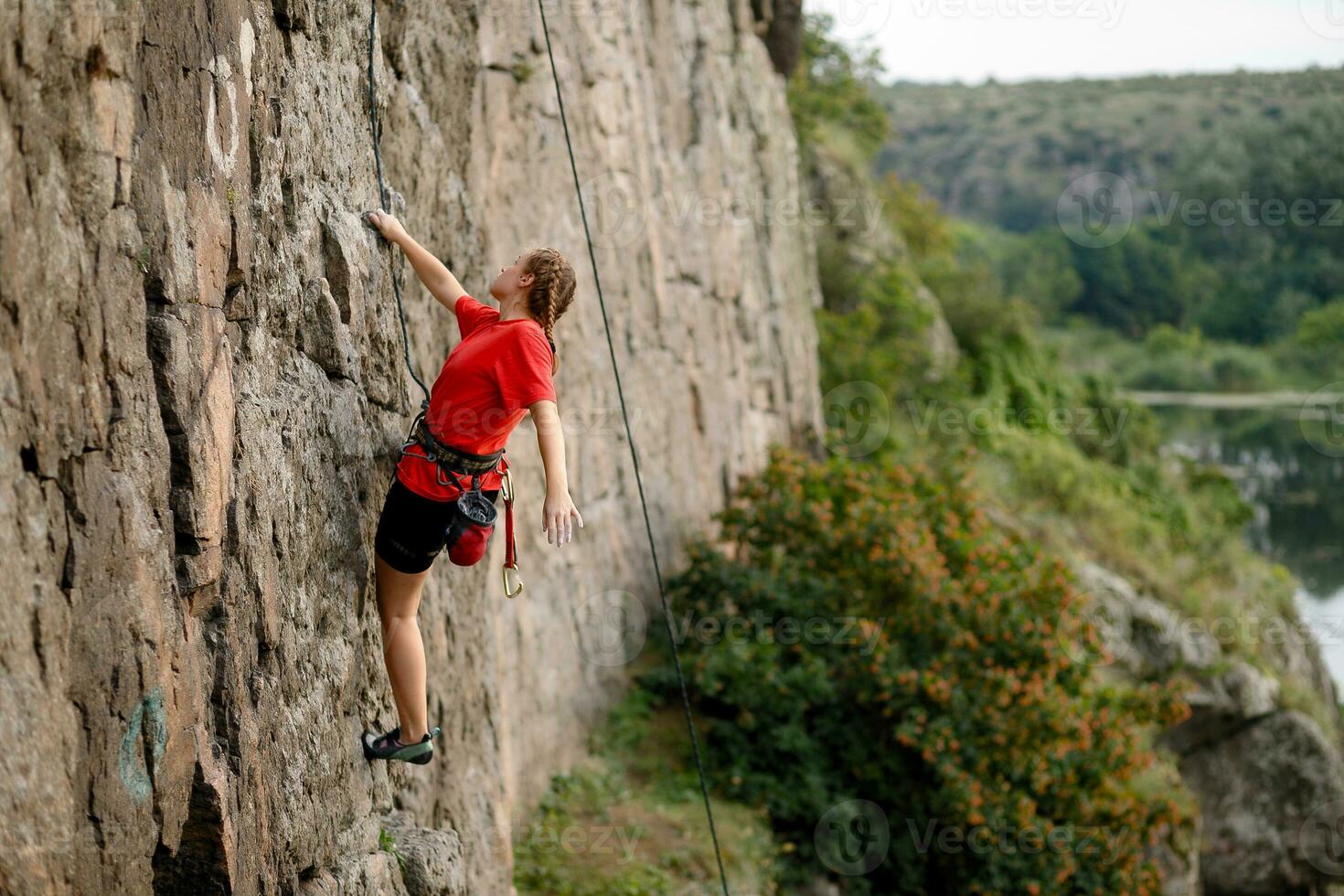 un' ragazza si arrampica un' roccia. donna impegnato nel estremo sport. foto