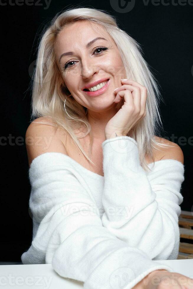 ritratto di un' bellissimo giovane attraente donna nel un' bianca maglione foto