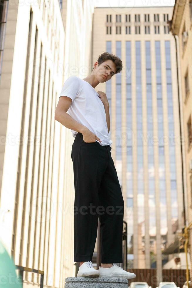 bello giovane fricchettone elegante uomo nel bianca camicia, nero pantaloni foto