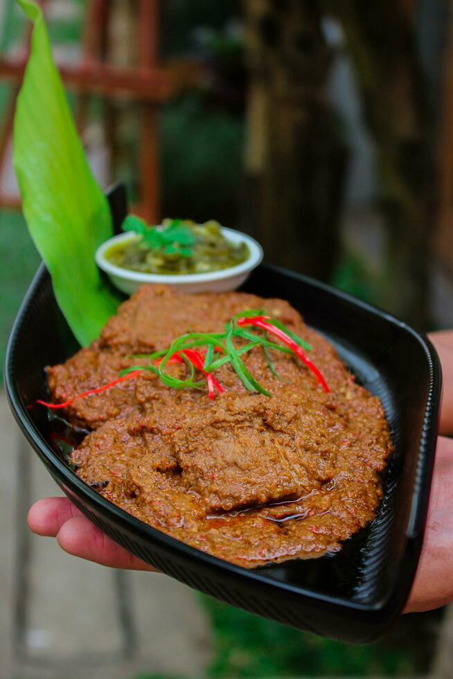 Manzo rendang è un' Minang piatto originario a partire dal il Minangkabau regione nel ovest sumatra, Indonesia. rendang ha stato lento cucinato e brasato nel un' Noce di cocco latte condito con un' erba e Spezia miscela foto