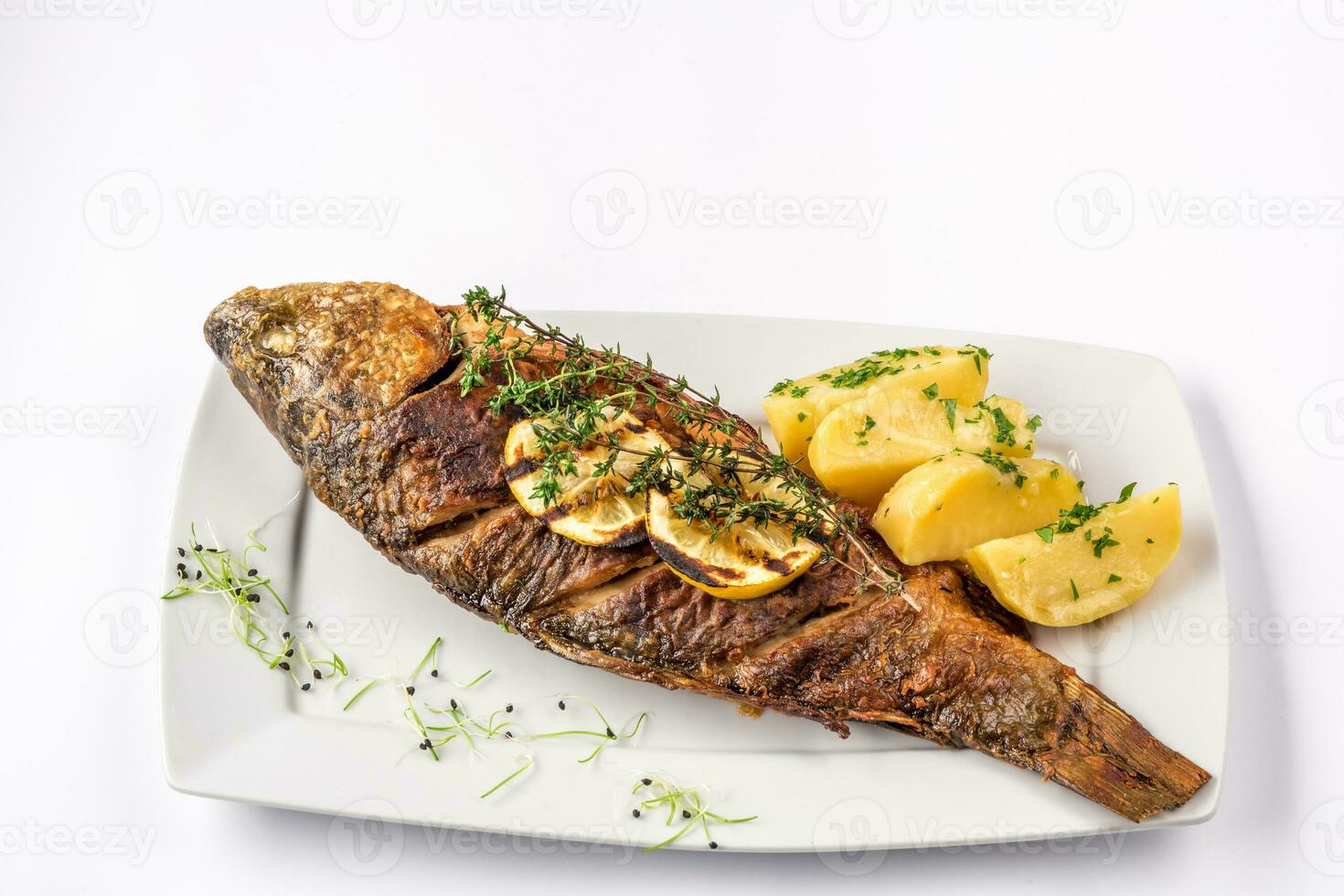 grigliato carpa pesce con rosmarino patate e Limone, vicino su foto