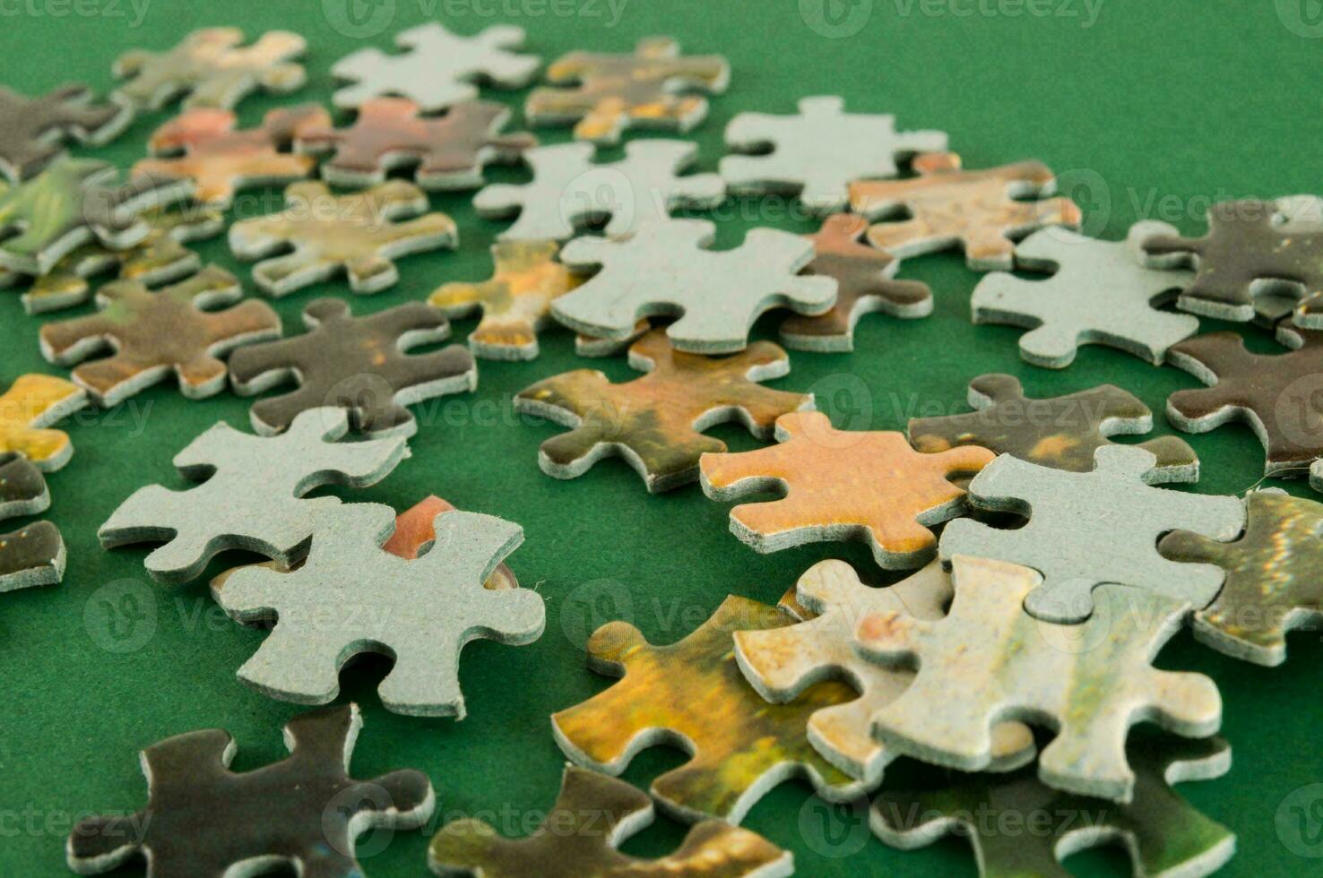 un' mucchio di puzzle pezzi su un' verde superficie foto