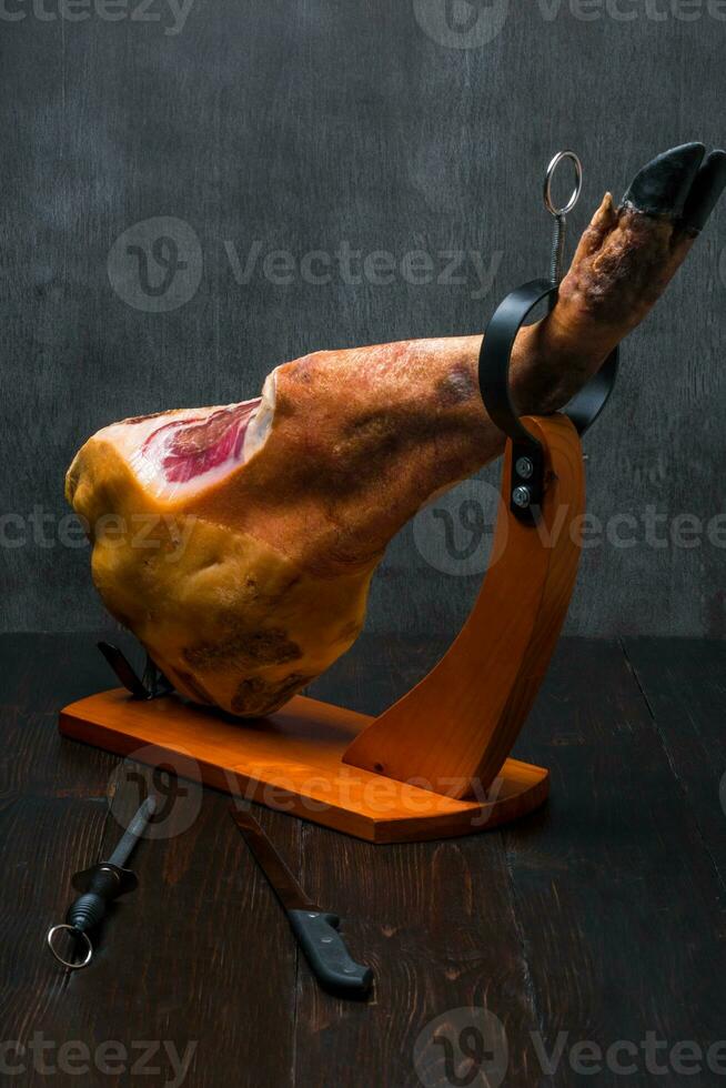 totale mediterraneo tradizionale jamon su un' di legno In piedi con un' coltello magro su un' tavolo. buio Immagine foto