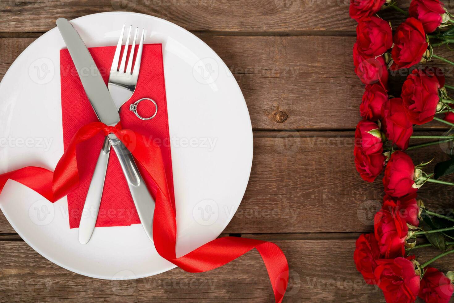 san valentino giorno tavolo ambientazione con piatto, forchetta, coltello, squillo, nastro e Rose. sfondo foto