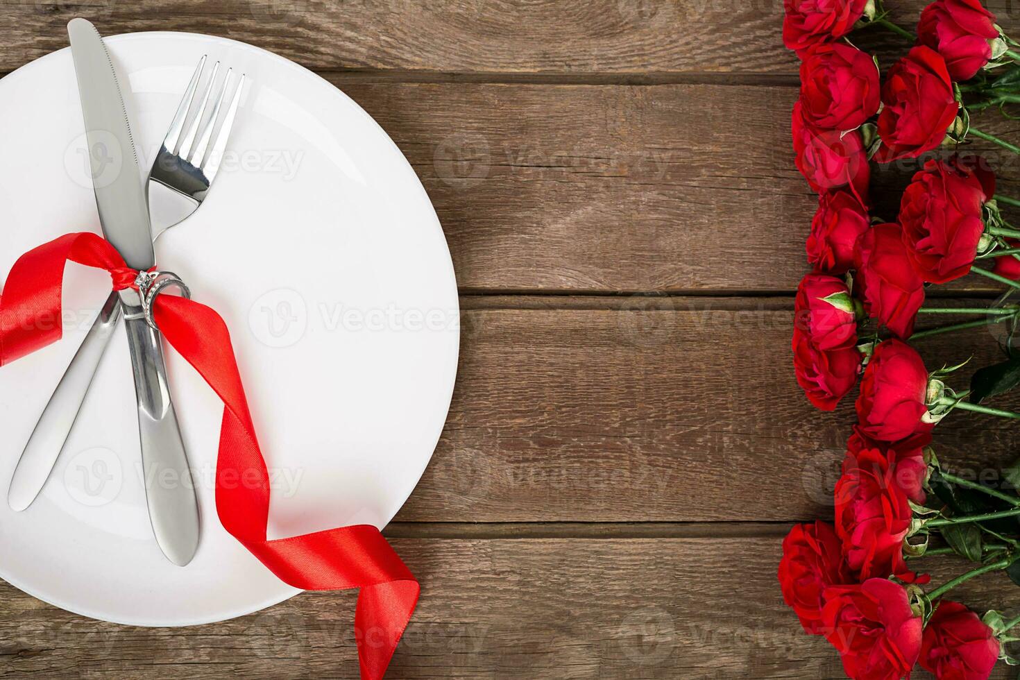 san valentino giorno tavolo ambientazione con piatto, forchetta, coltello, nastro e Rose. sfondo foto