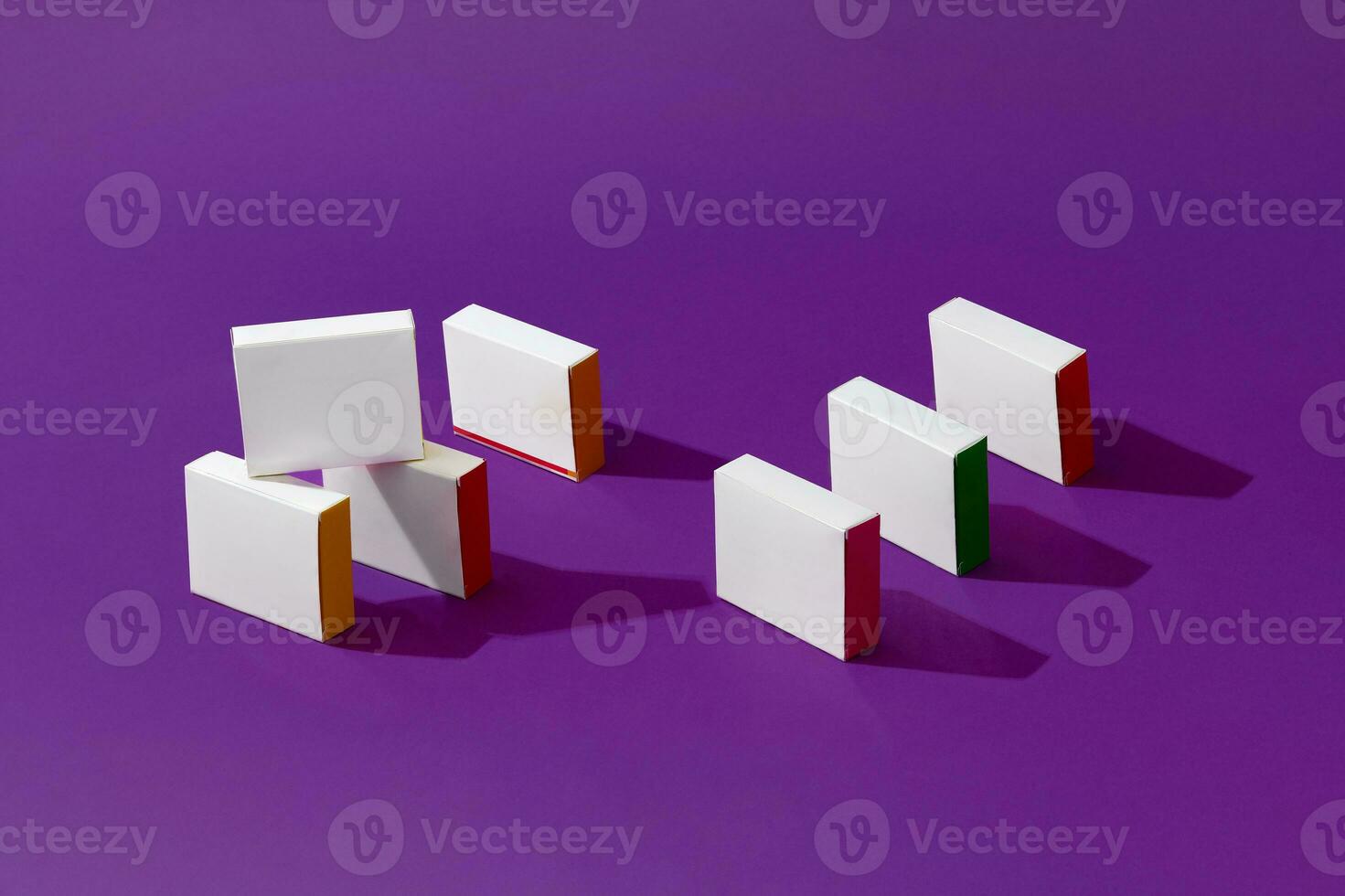 Sette piccolo proiezione di ombre cartone scatole o confezioni con colorato lati e no logo su viola studio sfondo. vicino su, copia spazio foto