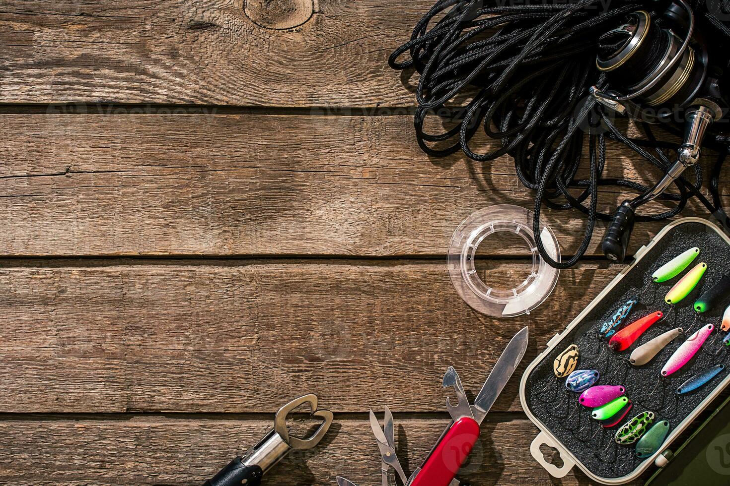 pesca affrontare - pesca Filatura, pesca linea, ganci e esche su di legno sfondo. foto