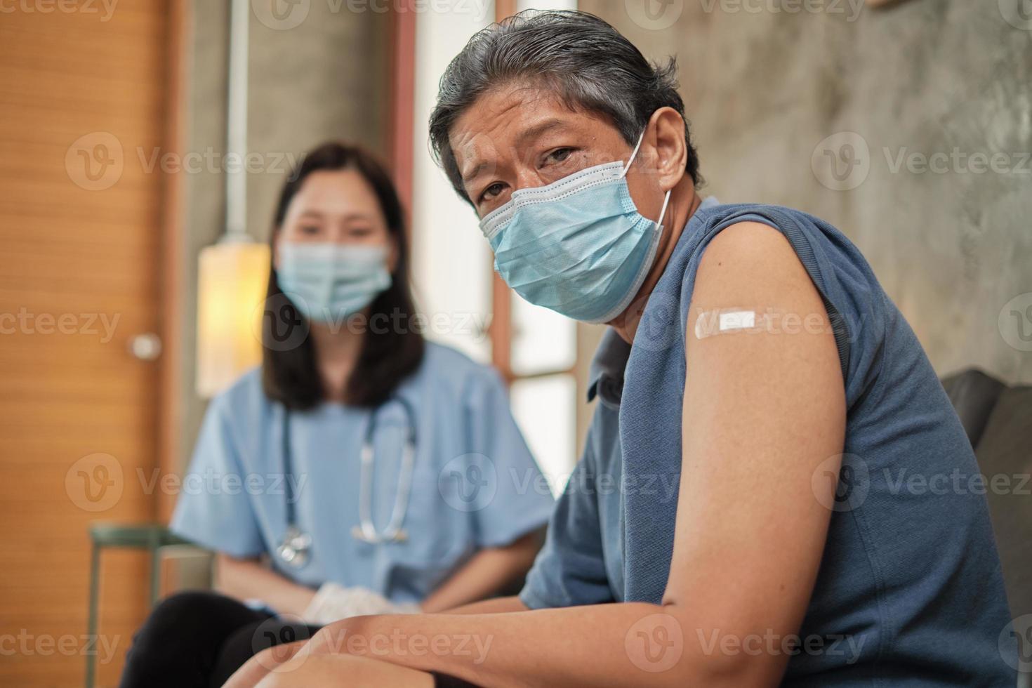 anziano paziente di sesso maschile con cerotto al braccio vaccinato. foto