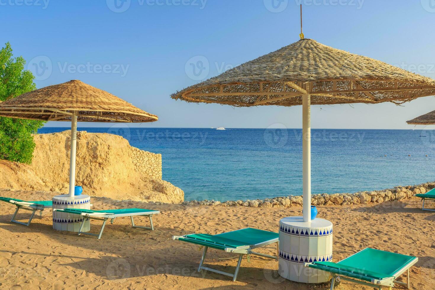 sole ombrelli e vuoto sdraio su il riva sabbia spiaggia foto