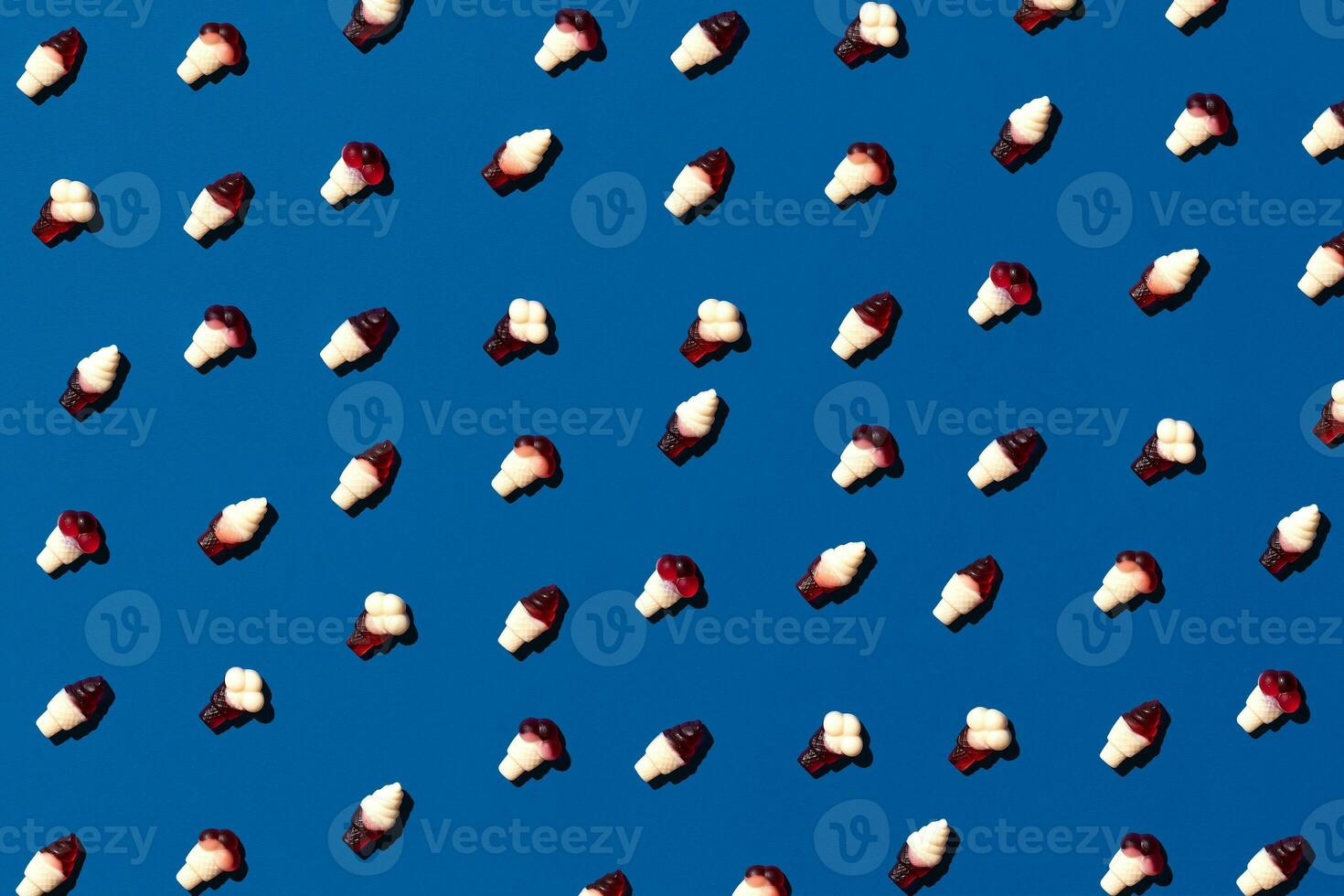 superiore Visualizza Immagine gustoso concetto, minimo dolce caramella gelatina fagiolo colorato modello su blu pastello. foto