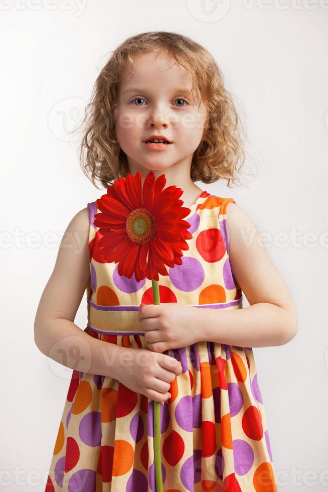 bambina con un fiore rosso foto