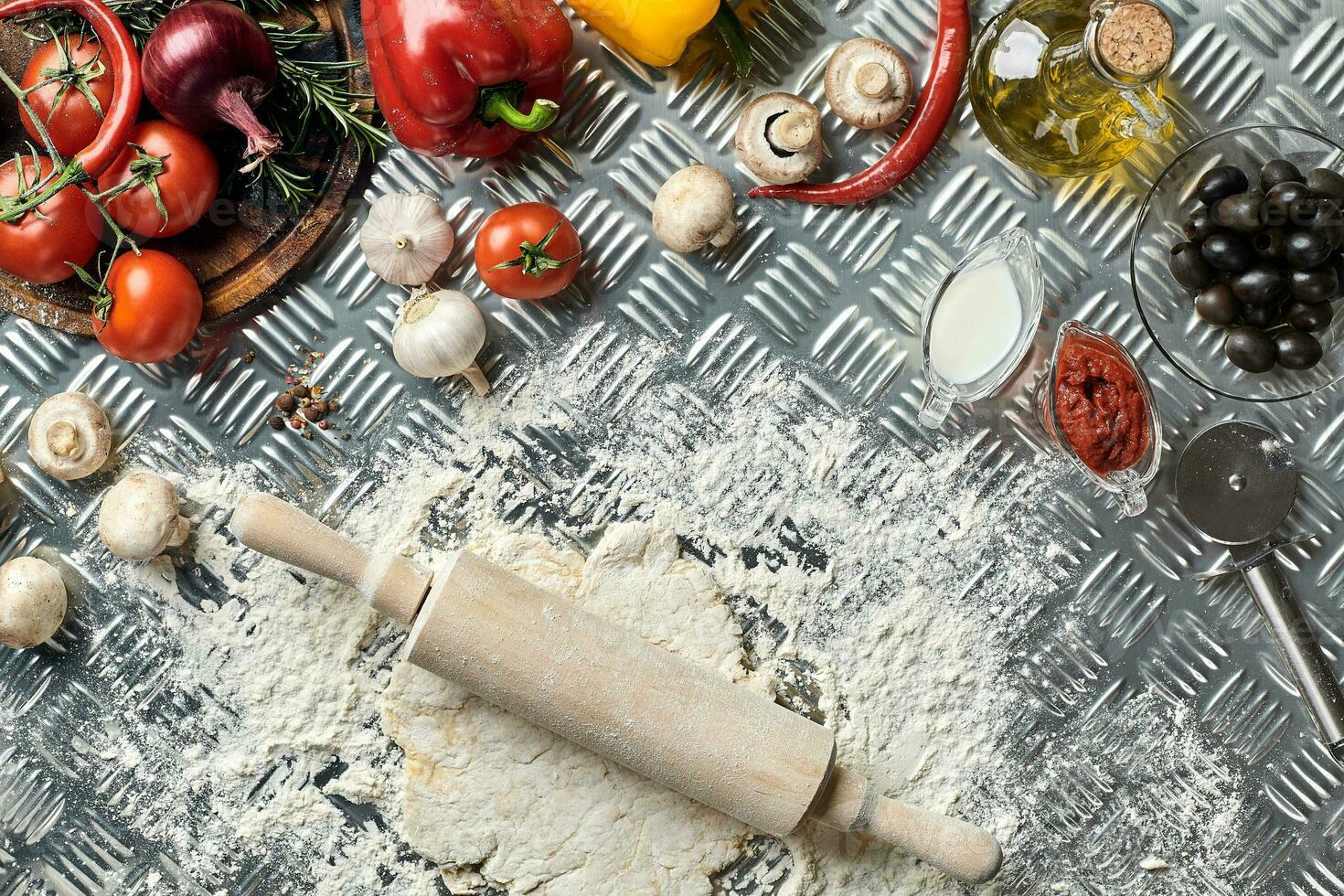 ingredienti e Impasto per fabbricazione pizze con un alto Visualizza su appena misto tumuli di Pasticcino, un' vaso di oliva olio e pentola di pomodoro salsa, alto Visualizza foto