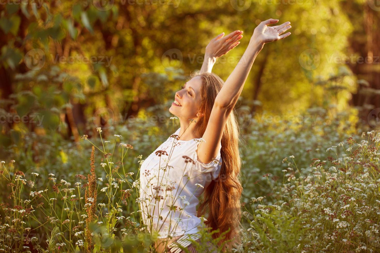 giovane donna felice tra i fiori di campo foto