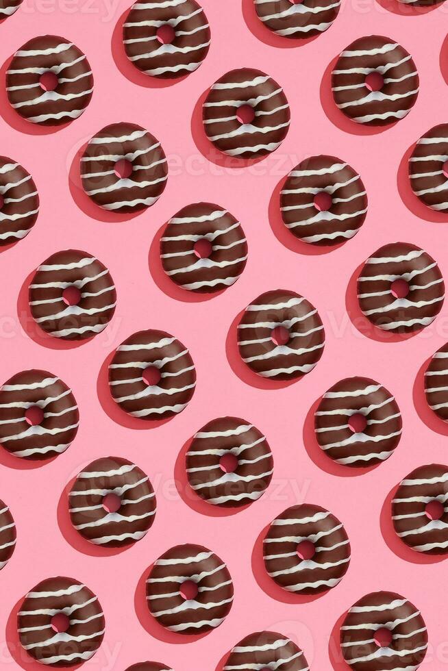 cibo design con gustoso cioccolato smaltato ciambella con bianca strisce su corallo rosa pastello sfondo superiore Visualizza modello foto