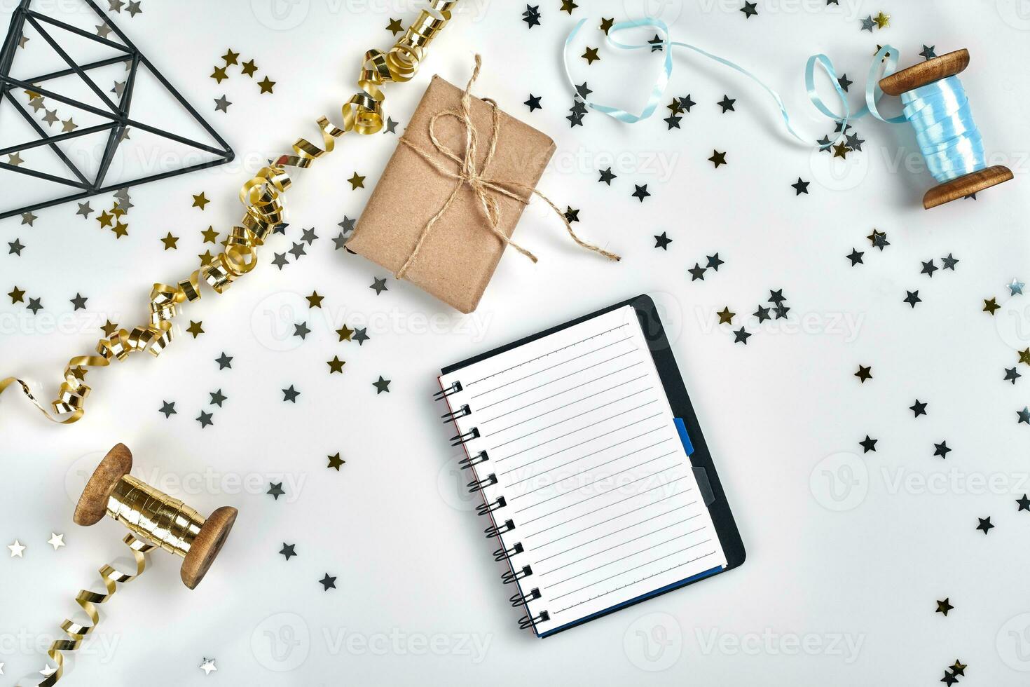 piatto posare Natale o festa sfondo con colorato nastri, decorazioni, coriandoli, e involucro carta. bloc notes per testo nel mezzo. foto