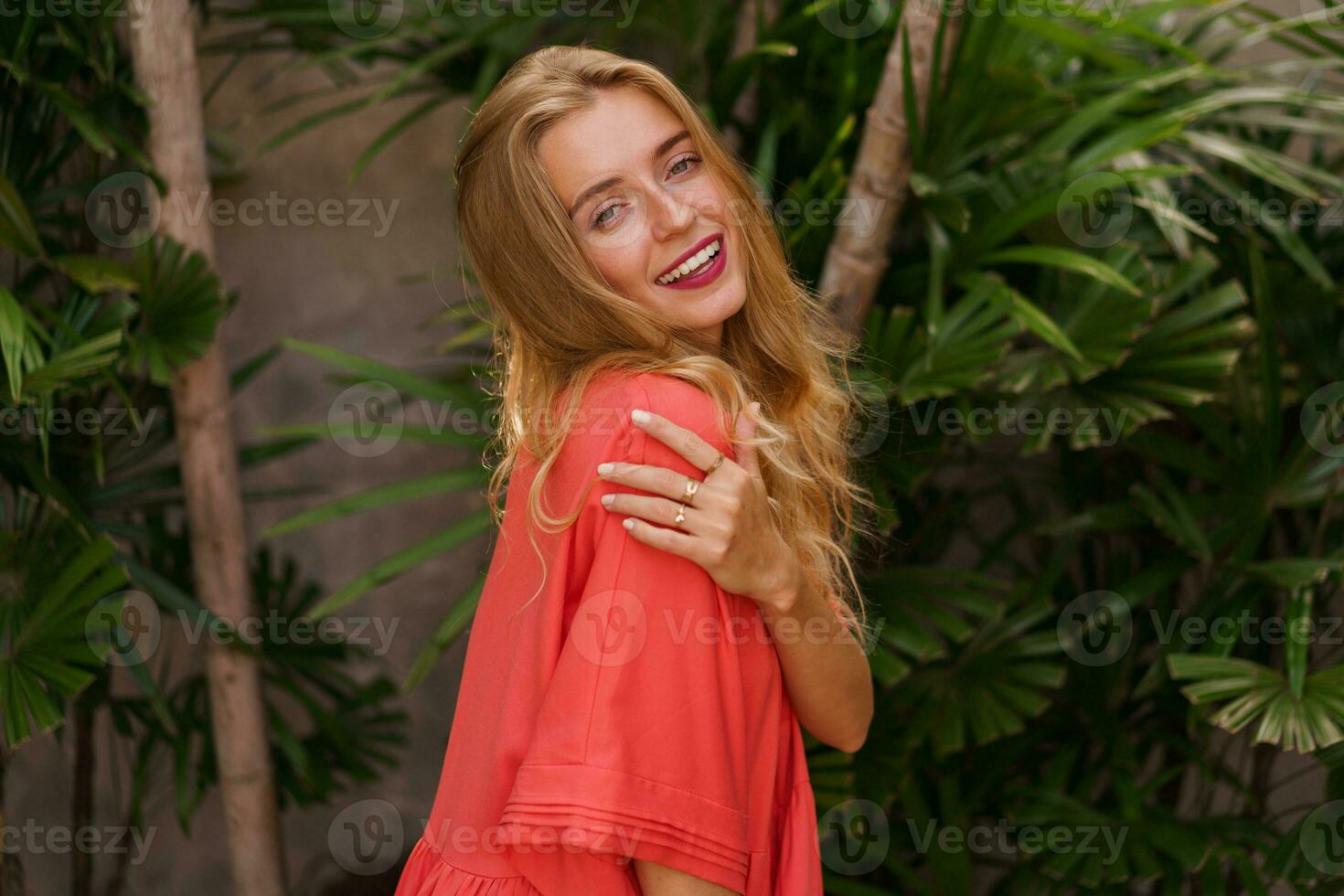 romantico biondo donna nel rosso vestito in posa nel elegante tropicale villa. estate vacanza. foto