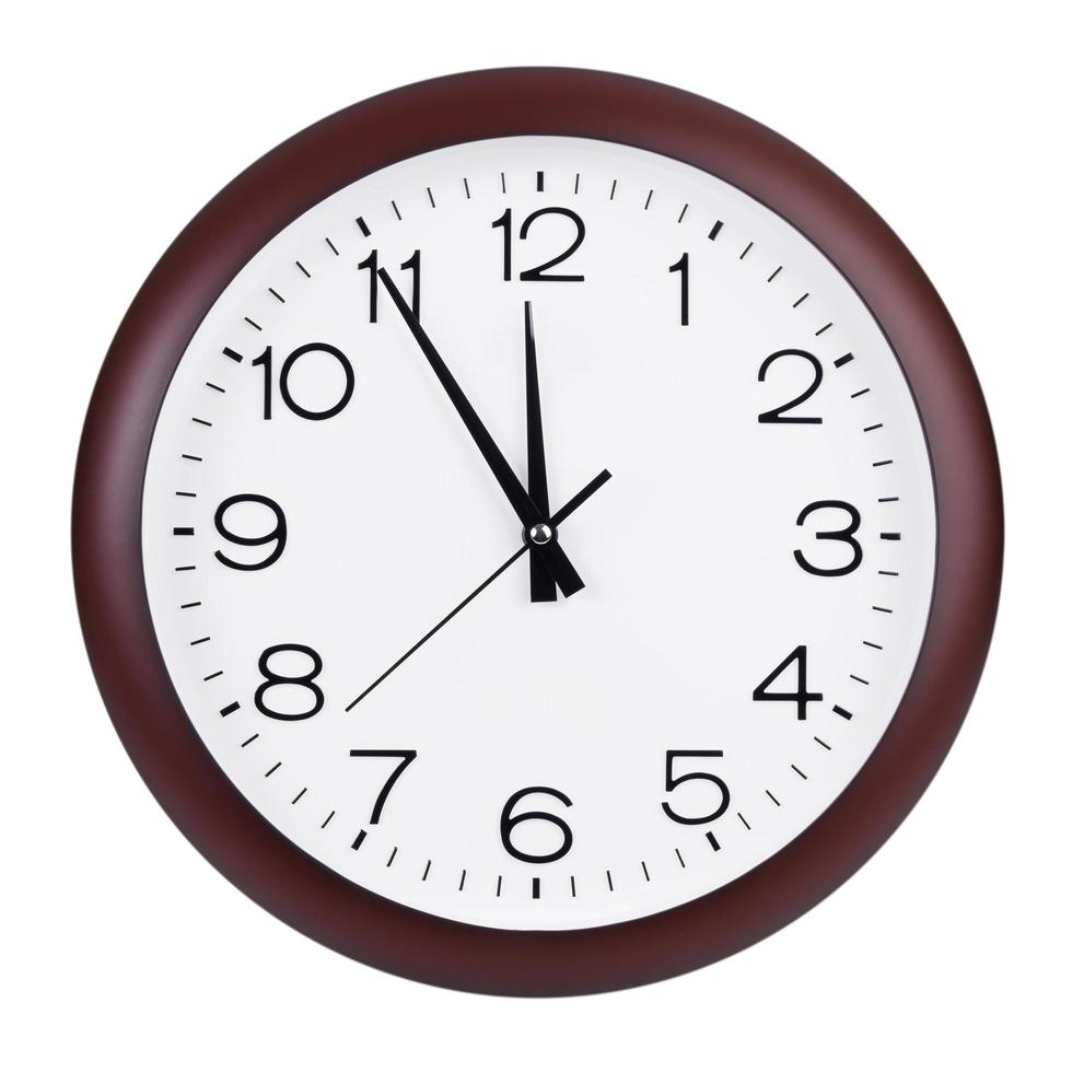l'orologio rotondo mostra cinque minuti a dodici foto