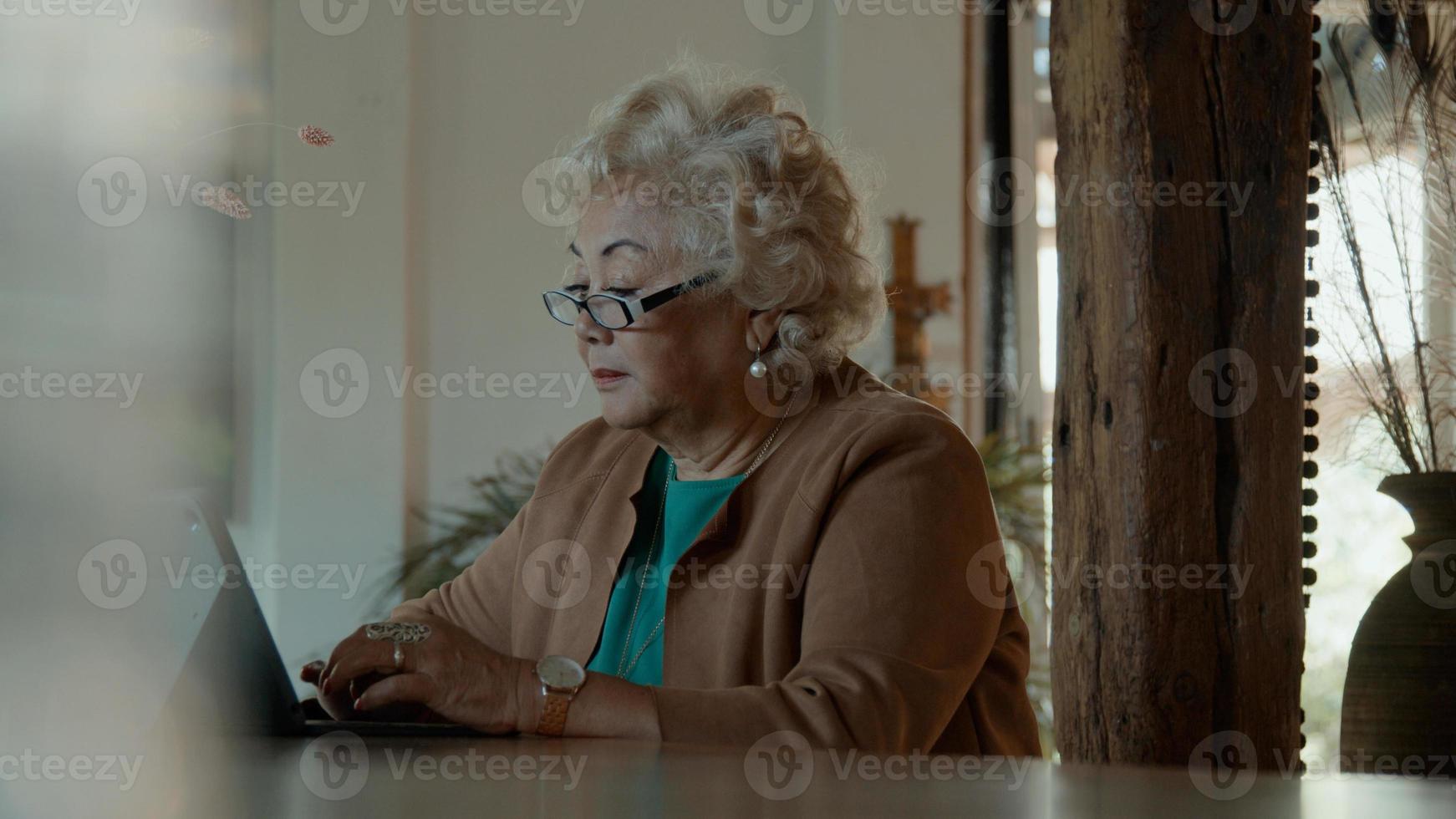 la donna si siede al tavolo digitando sul laptop foto