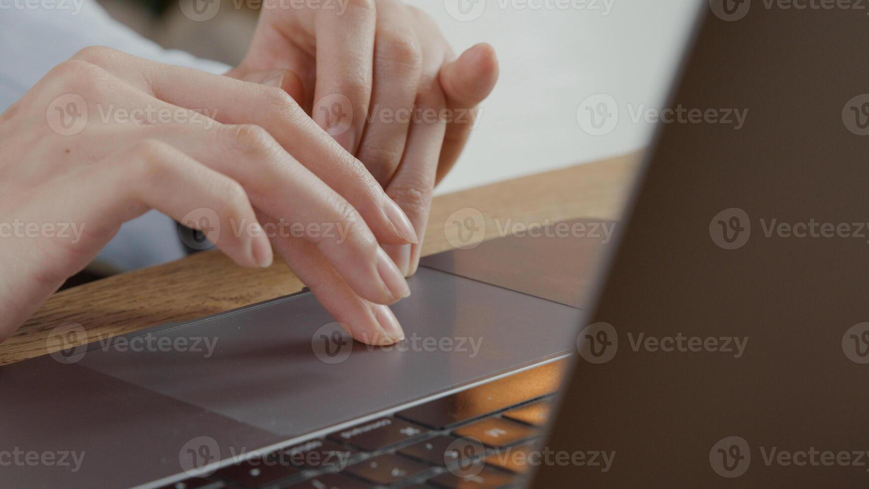 primo piano delle dita della giovane donna che si spostano sul touch pad del laptop foto