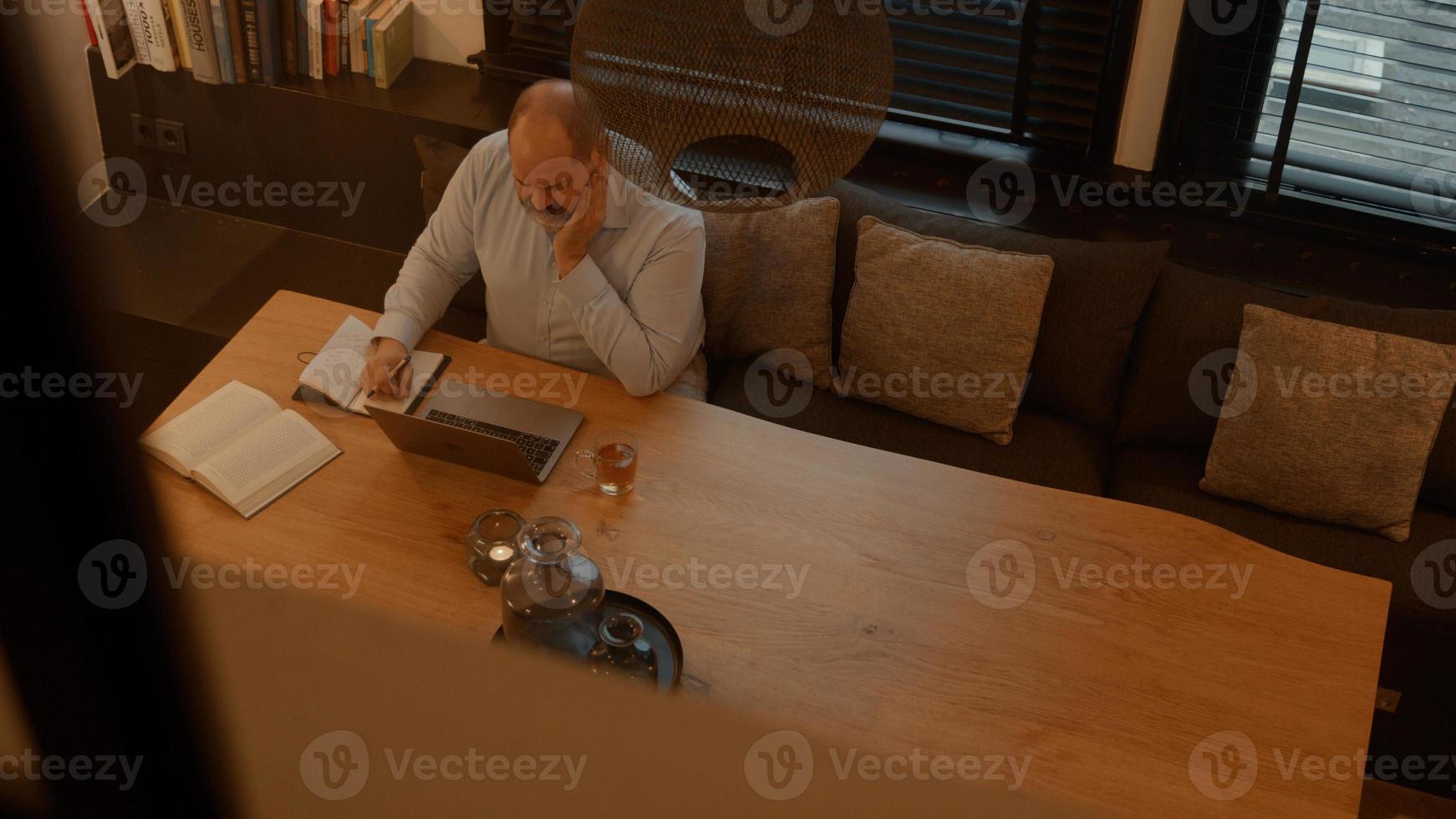 uomo al tavolo con chiamata in linea sul computer portatile foto