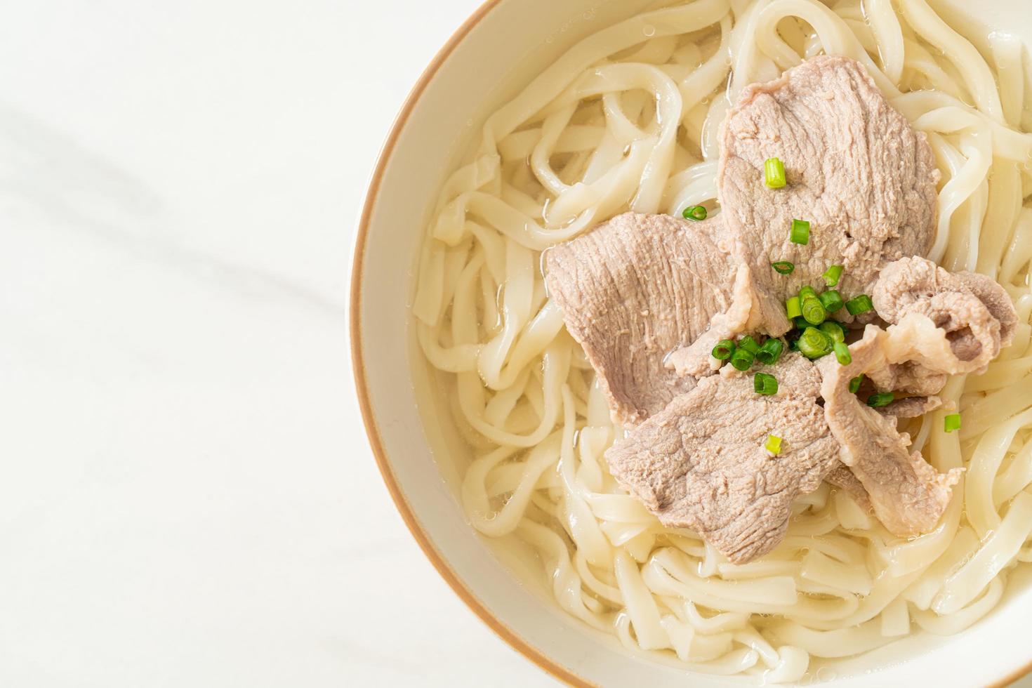 udon noodles con maiale in zuppa chiara foto