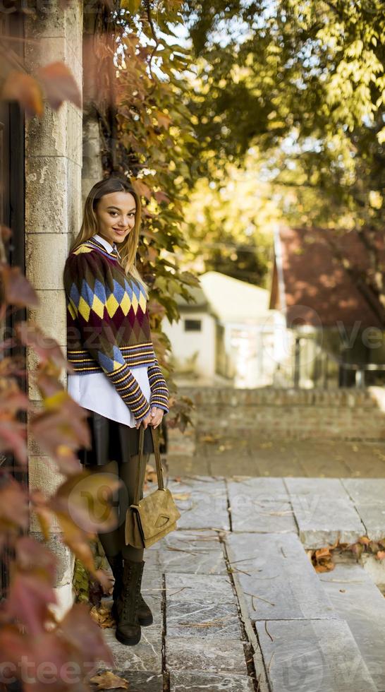 giovane donna in piedi fuori alla soleggiata giornata autunnale foto