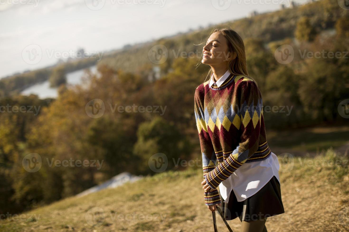 giovane donna in piedi fuori alla soleggiata giornata autunnale foto