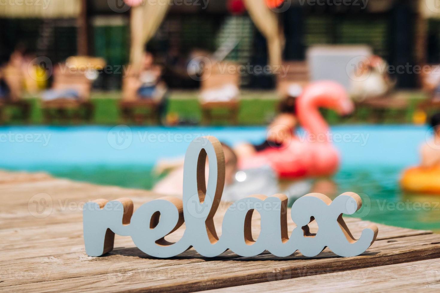 iscrizione relax blu sullo sfondo sfocato della piscina foto