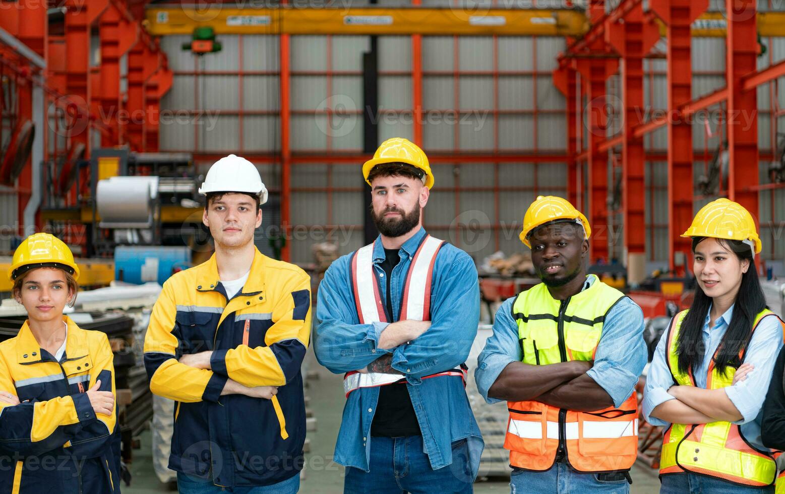 ritratto di fiducioso fabbrica lavoratori in piedi con braccia attraversato e guardare a telecamera foto