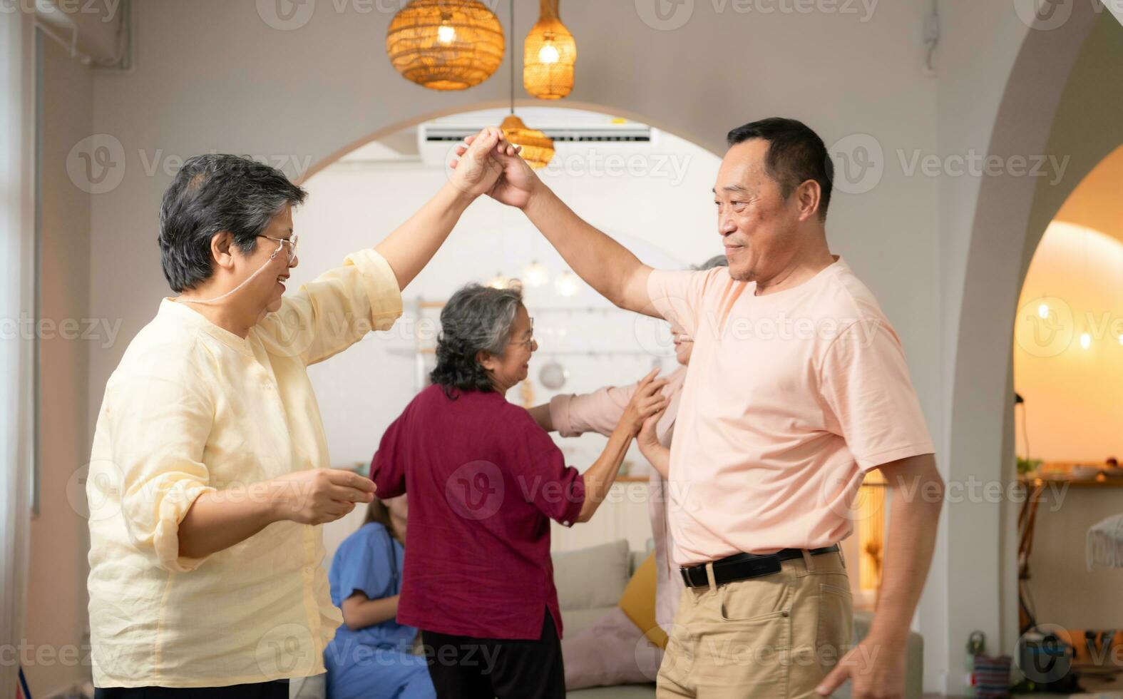 un' gruppo di anziano asiatico persone danza insieme felicemente, nel il la pensione casa foto