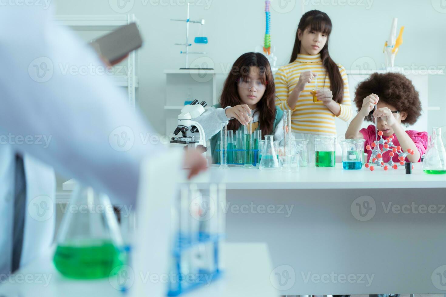 nel il scienza aula, un asiatico bambino scienziato sperimentando con scientifico formule con sostanze chimiche foto