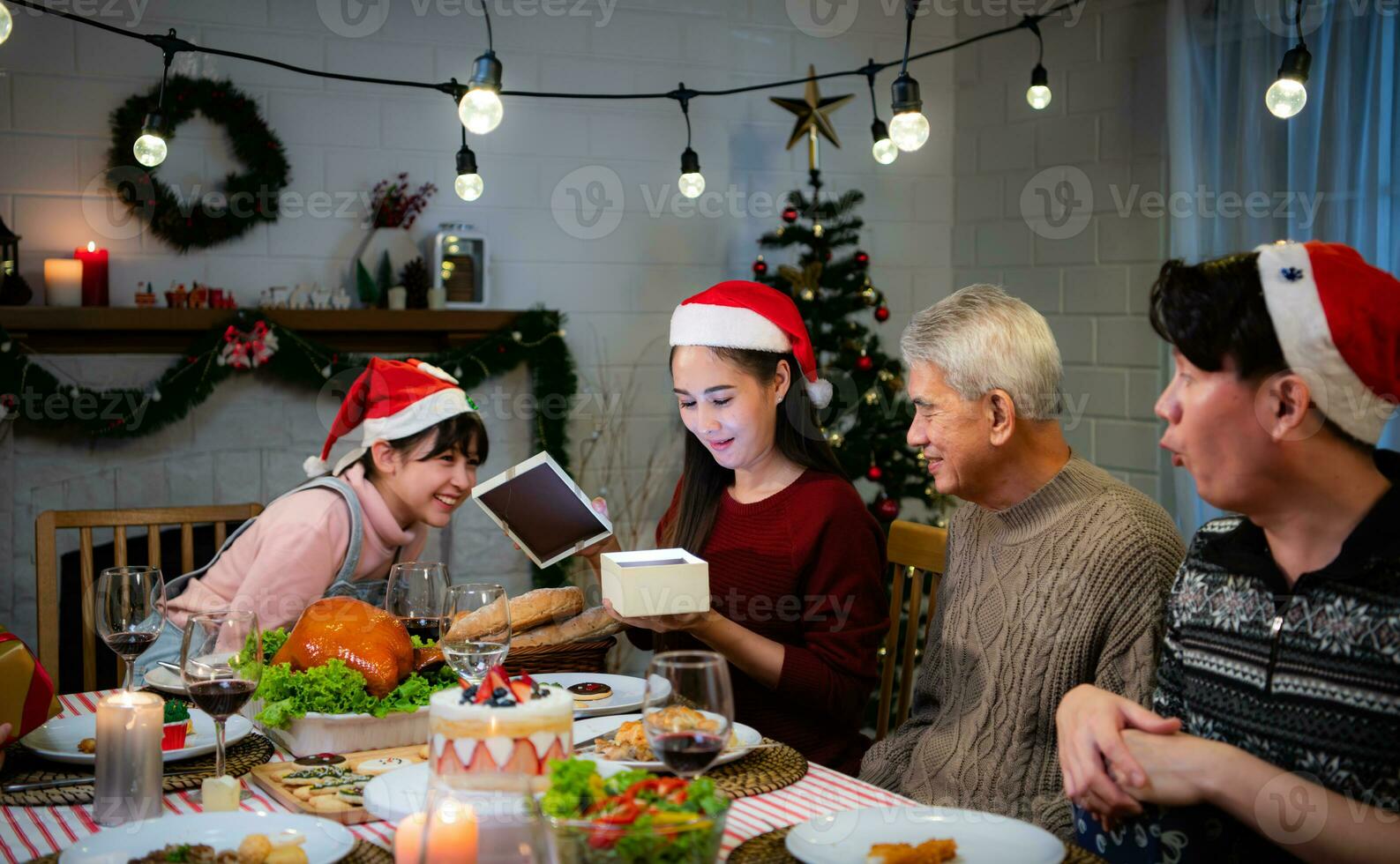 contento asiatico famiglia festeggiare Natale a casa. con il attività di dando i regali per ogni altro tra famiglia membri foto