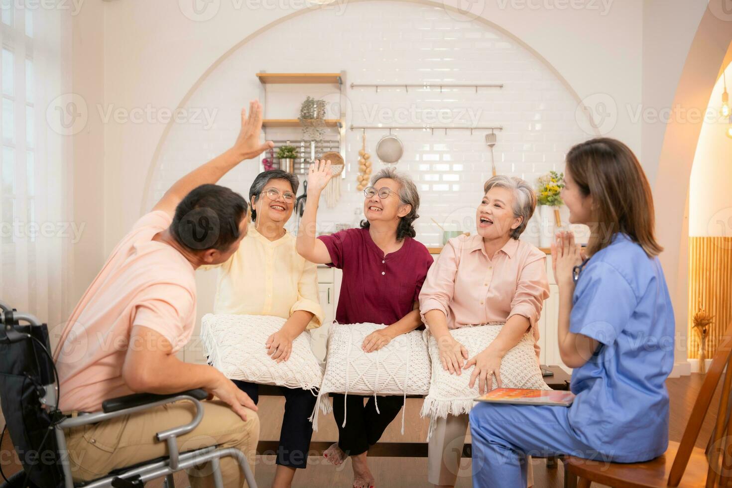 gruppo di anziano e anziano uomo nel sedia a rotelle con infermiera a assistenza infermieristica casa giocare un' divertimento gioco di colpire ogni altri mani. anziano persone nel assistenza infermieristica casa concetto foto