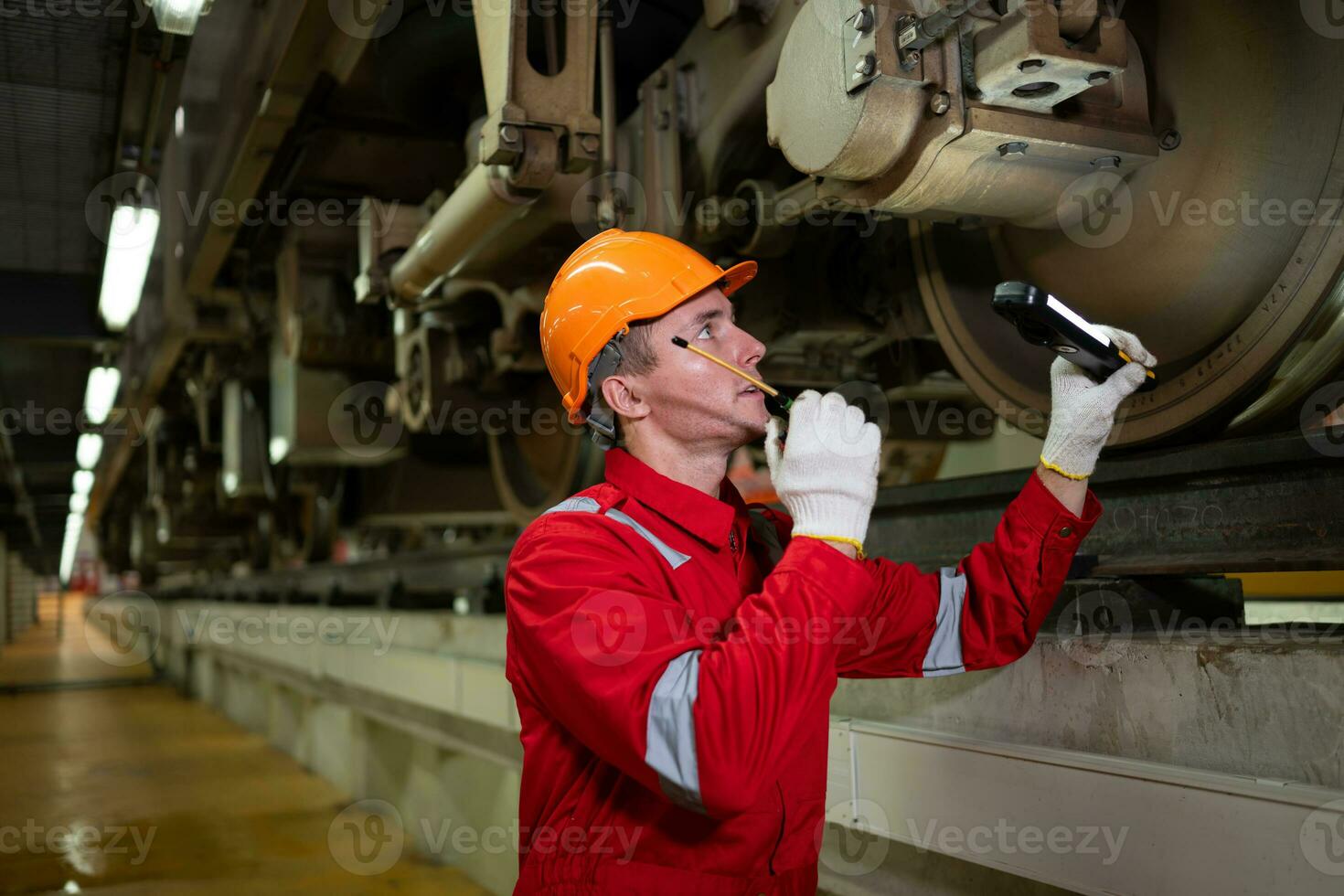 elettrico treno ingegnere uso un' Ricetrasmittente per ispezionare elettrico treno macchinari secondo per ispezione il giro dopo il elettrico treno è parcheggiata nel il elettrico del treno riparazione negozio foto