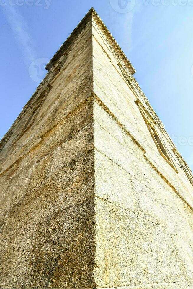 il superiore di un' pietra Torre con un' blu cielo nel il sfondo foto