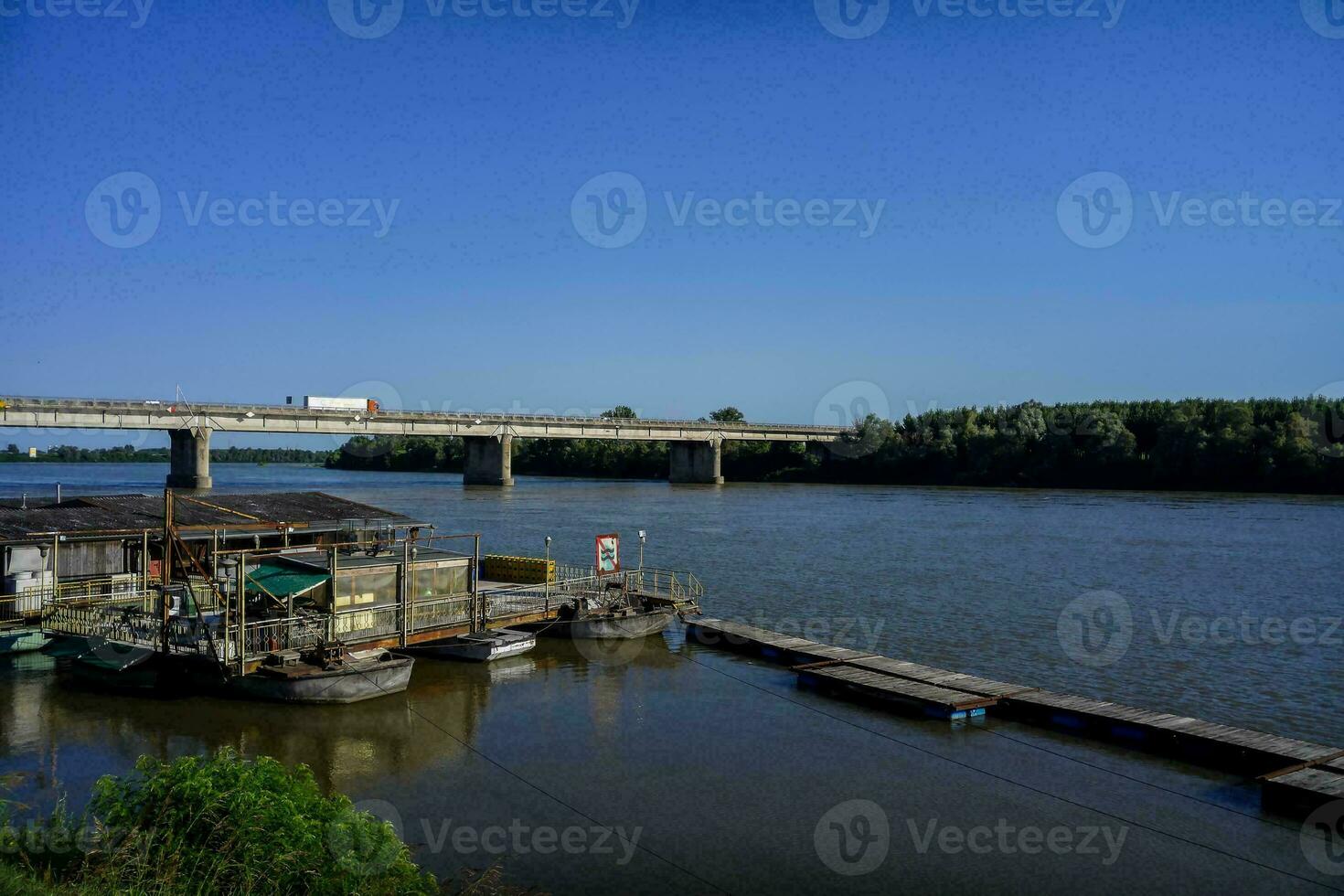 un' ponte al di sopra di il fiume con Barche attraccato su esso foto