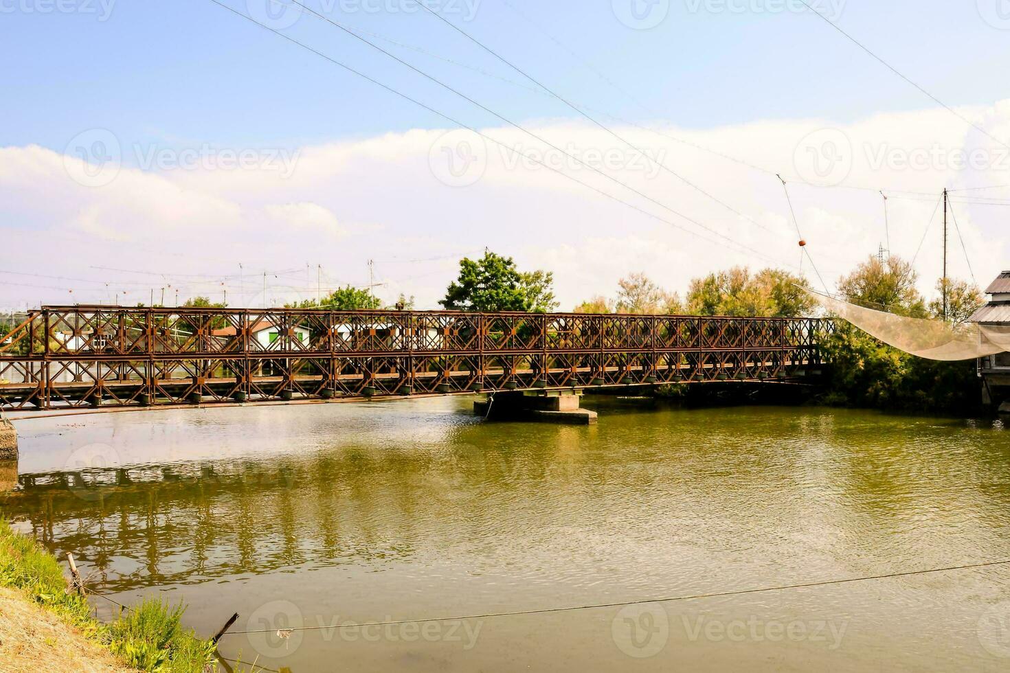 un' ponte al di sopra di un' fiume con un' treno su esso foto