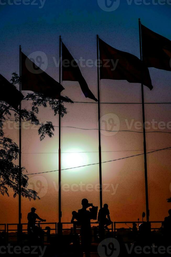 il sole imposta dietro a il bandiere di Vietnam e Cambogia foto