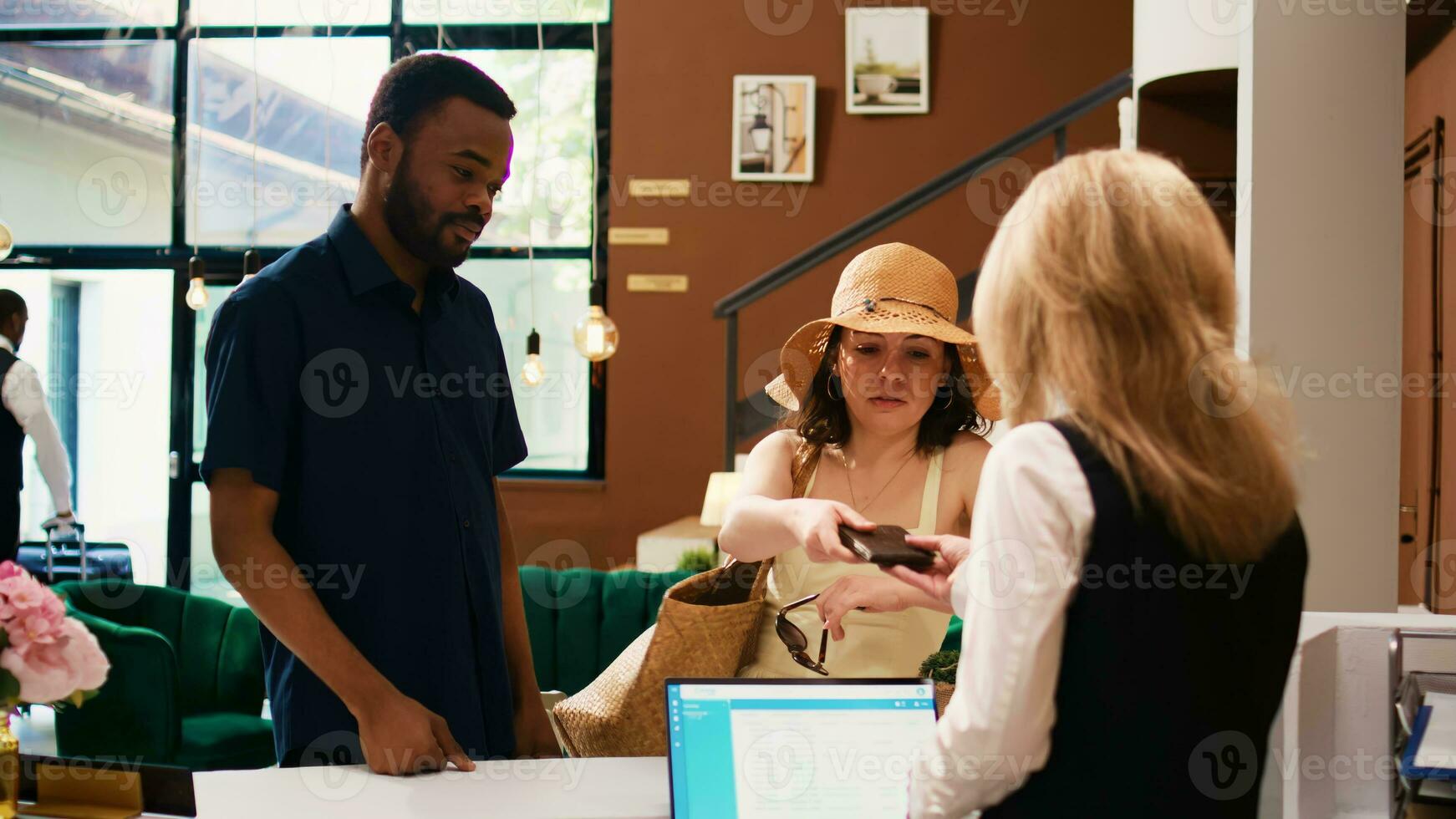 Hotel ospiti mostrando passaporti a davanti scrivania, utilizzando id documenti per dai un'occhiata nel registrazione procedura. addetto alla reception verifica identificazione documenti per Registrati persone a ricorrere. foto