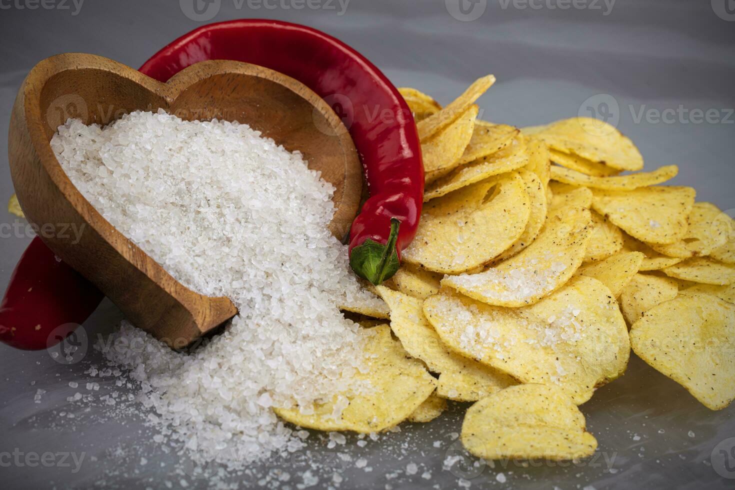 patatine fritte con rosso Pepe e cosparso sale su un' grigio sfondo avvicinamento. foto