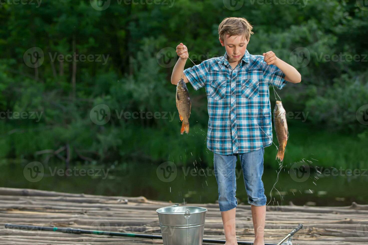 un' pescatore ragazzo ammira il suo presa. pesca bambino. foto