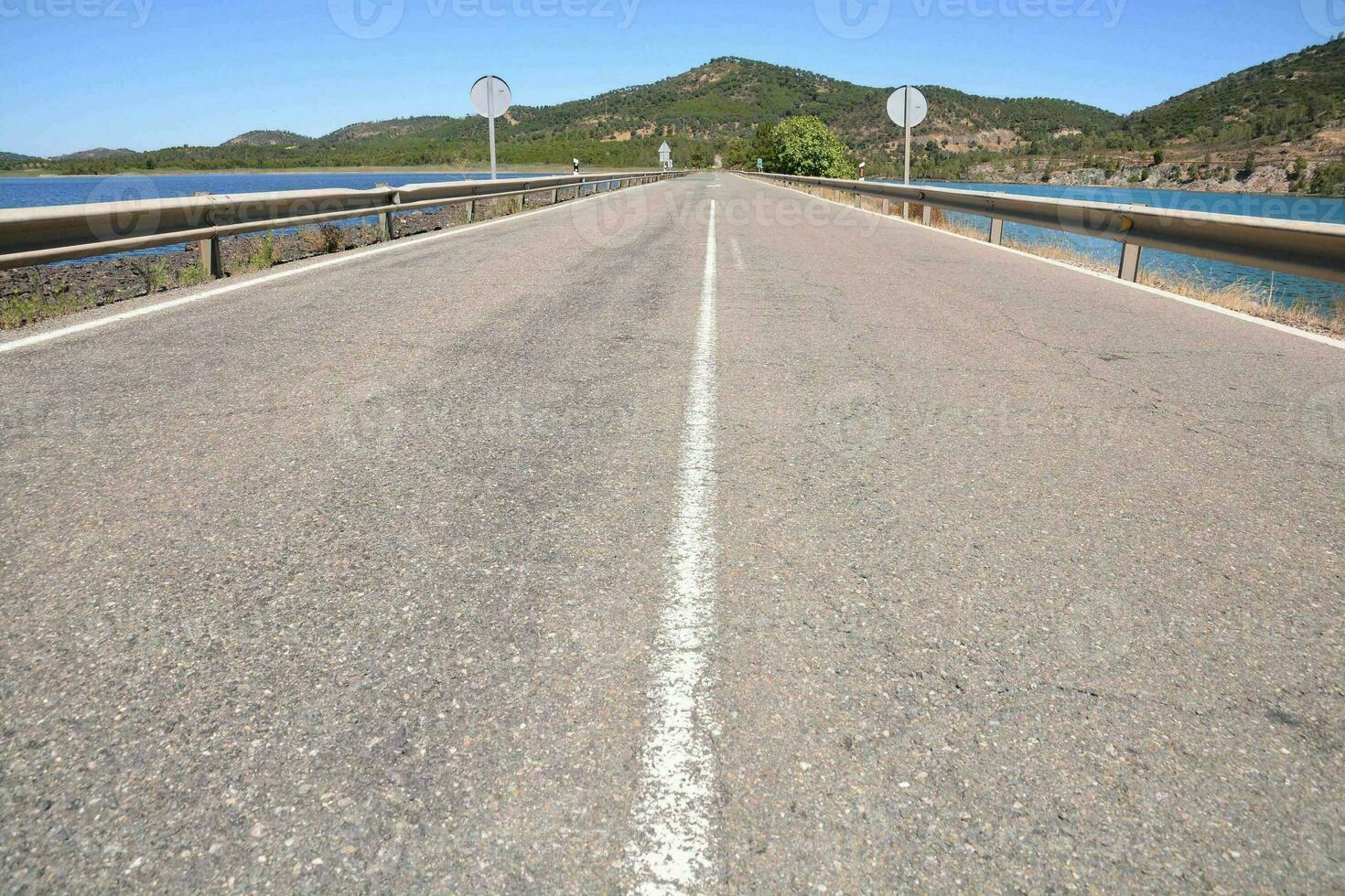 un' lungo vuoto strada con un' cartello su esso foto