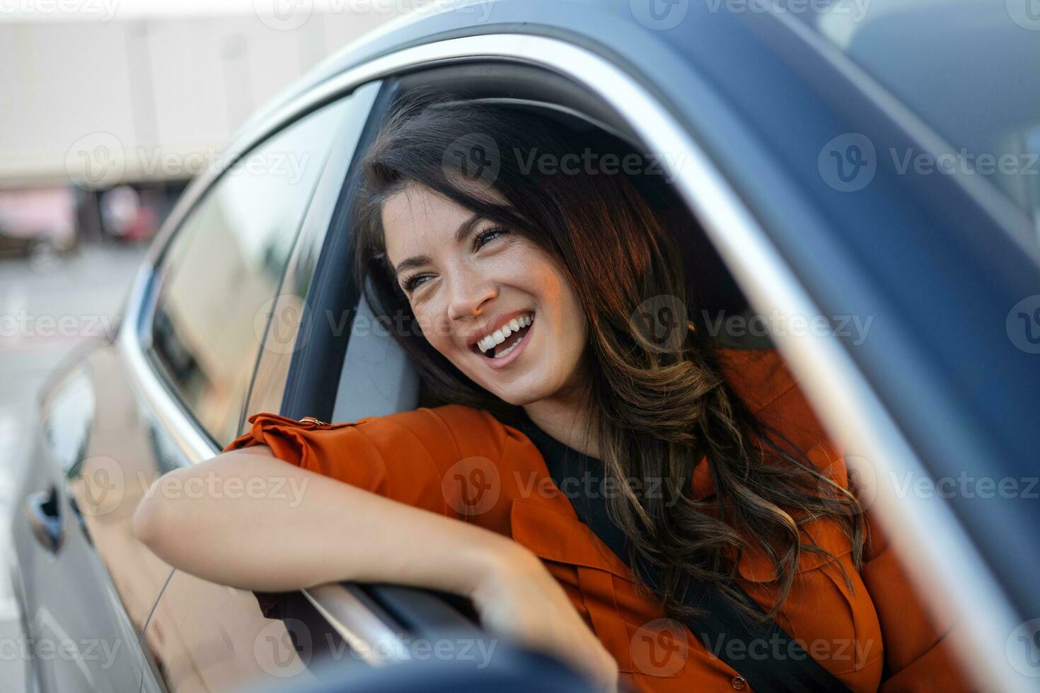 ritagliata tiro di un attraente giovane donna pendente su di un' auto finestra su un' strada viaggio foto