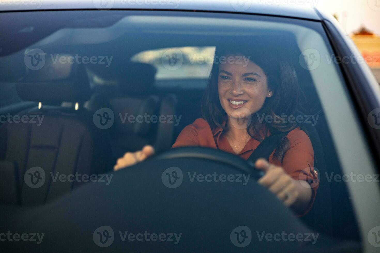 bellissimo giovane donna guida sua nuovo auto a tramonto. donna nel macchina. vicino su ritratto di piacevole guardare femmina con lieto positivo espressione, donna nel casuale indossare guida un' auto foto